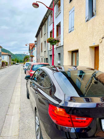 Deserted cosy street with parking cars, vertical photoの写真素材