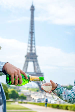 Bottle and glass of champagne on the background of the Eiffel Tower.の写真素材