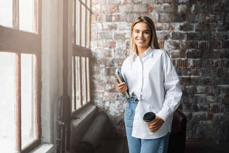 Beautiful model posing at photo set. Smart girl having coffee at lunch time. Career opportunities,...