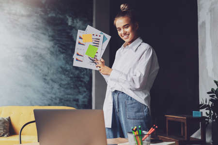 Business woman holds documents, communicates through web camera. Remote work of employee of...
