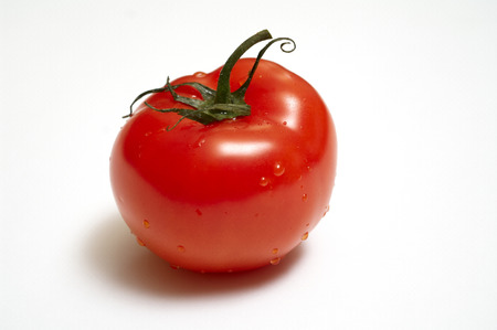 Single juicy tomato with peduncle isolatel on white backgroundの写真素材