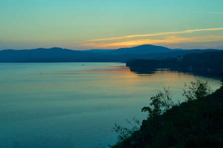 View to lake with mountain range on another shore.の写真素材