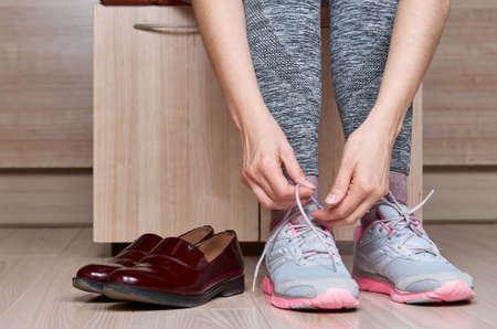 Woman changing shoes before training.