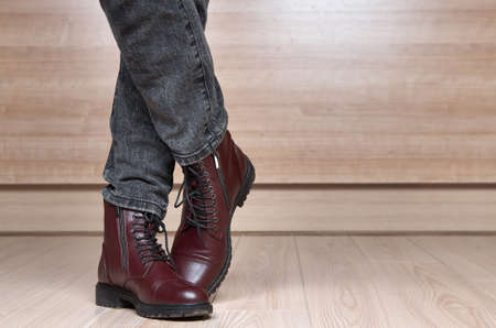 Closeup of woman legs in red leather boots and black jeansの写真素材