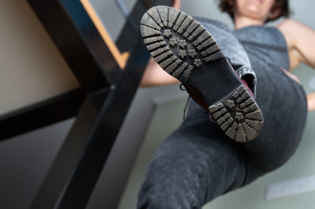 Low angle view of a caucasian woman showing her sole while standing on staircase.の写真素材