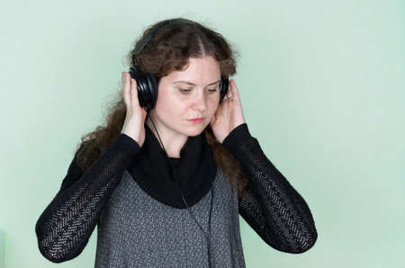 Close-up portrait of beautiful young woman with headphones around neck.の写真素材