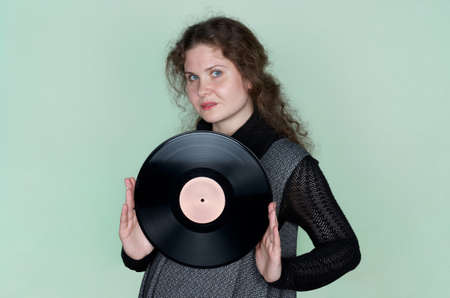Smiling woman with curly hair listening to music with headphones and dancingの写真素材