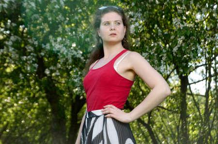 Portrait of beautiful young woman in apple trees blooming park on a sunny day. spring timeの写真素材