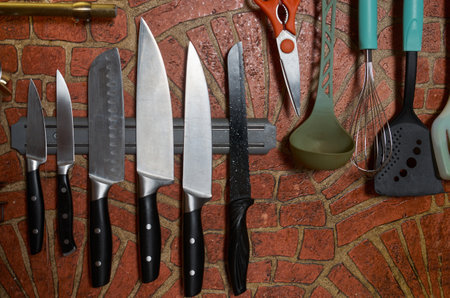 Brick-decorated kitchen wall with kitchen utensils hanging on itの写真素材