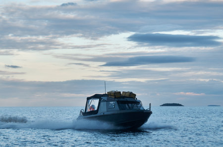 Dark speedboat goes on the waterの写真素材