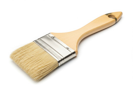 A paint brush with a wooden handle and light-colored bristles is displayed against a clean white backdrop. The brush is clean and ready for use in various painting or artistic projects.の素材