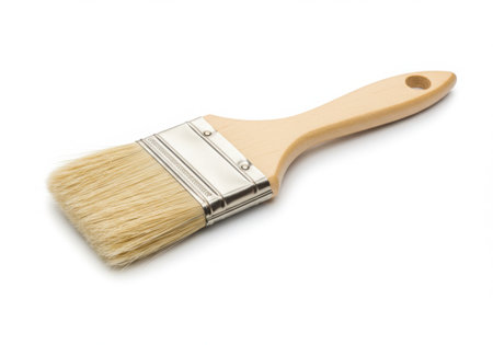 A paint brush with a wooden handle is displayed against a white backdrop. The brush features light-colored bristles and a neutral-toned handle, suggesting its use for various painting projects.の素材