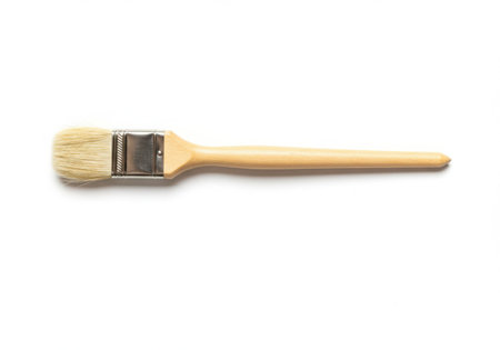A paint brush with a wooden handle and light bristles is displayed against a white background. The brush is clean and unused, suggesting readiness for painting or artistic endeavors. The image is well lit and focused.の素材