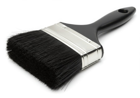 A close-up shot of a paintbrush with black bristles and a black handle. The brush is isolated on a white background, showcasing its details and form, perfect for illustrating painting or art supplies.の素材