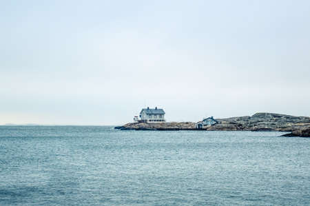 Tiny blue lighthouse on swedish coastline pastel shades of blueの写真素材