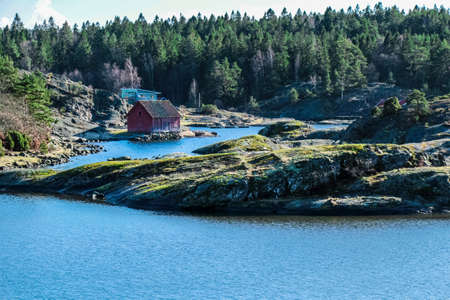 Typical swedish house on a lake surrounded by pine treesの写真素材