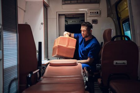 Corpsman sits in the ambulance car and packs medical bagの写真素材