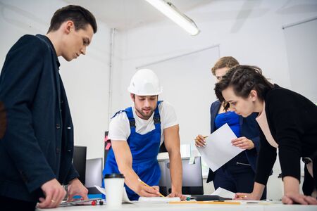 Engineers discussing the efficiency of the construction plan in their office