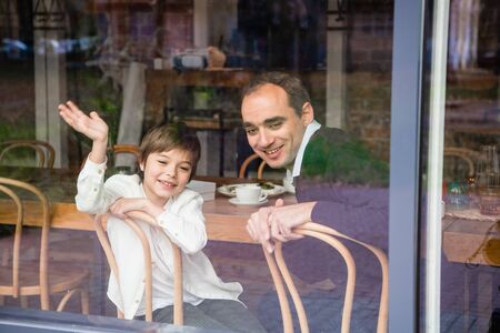 Father and son sitting at the table on a porch