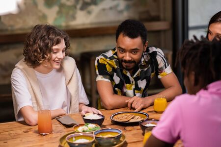 Multi-ethnic group of students having a meal in a cafeの写真素材