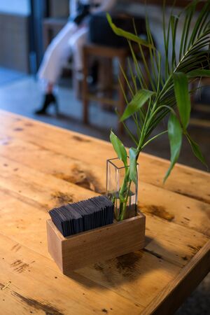 Interior decor, green plants in a vase on a wooden table, texture of barked wood.