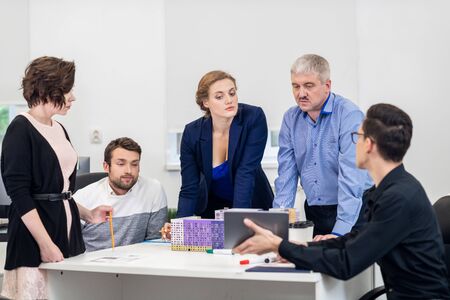 Office business meeting. The team is sitting at a table in a lumの写真素材