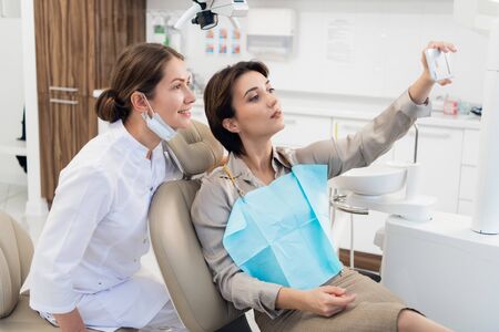 A young woman taking a selfie after a successful dental check-upの写真素材