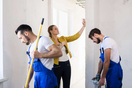 Repairers cover the wall with mortar with a rollerの写真素材