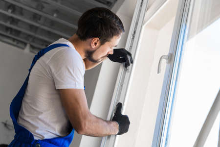 The foreman installs a window frame in the room