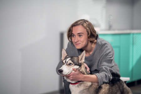 A happy boy holding his dog, posing for the pictureの写真素材