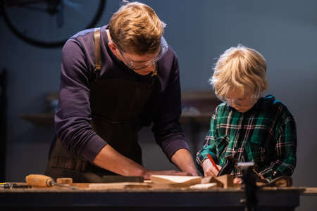 brothers prepare a gift made of wood for their mother in the garage.の写真素材