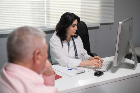 Experienced nurse checking the senior patients medical history.