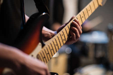 close-up of the hands of a musician playing an electric solo guitar in the Studioの写真素材