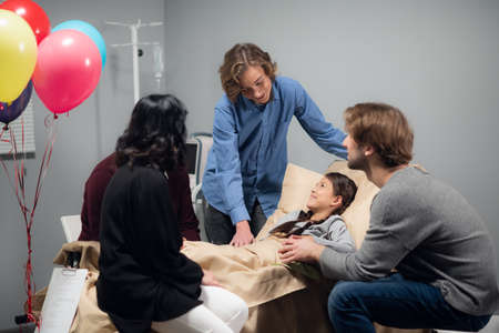 A grandpa, two brothers and a mom visiting their little girl in a hospital, they brought her...