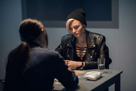 cute drug dealer being questioned at police station.の写真素材