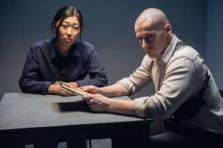 Portrait of a handsome investigator and his young assistant at the police station.