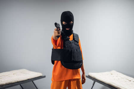 A girl with a mask, bulletproof vest and a gun escapes from prison.
