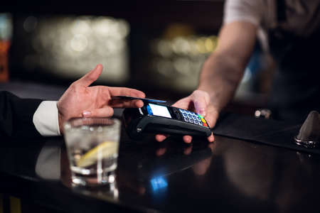 the bartender accepts payment by credit card at the bar.