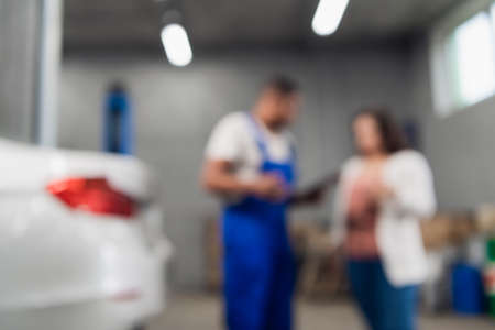 Repairer talking with client about car repairの写真素材