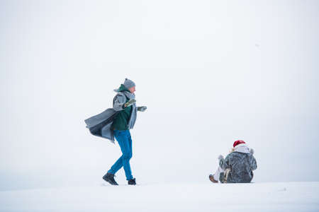 During a walk in winter, a guy and a girl have fun in a snow field.の写真素材