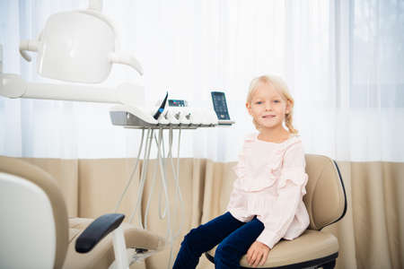 A little girl sitting in the dentistry office.の写真素材