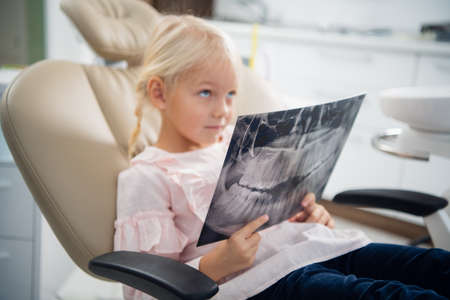 A small girl listening to a doctor, who is explaining her what she sees on the x-ray.の写真素材