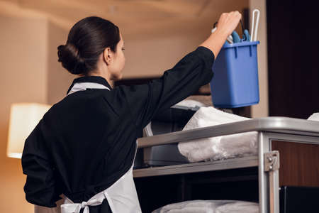 A housekeeping lady in a uniform cleaning the room.の写真素材