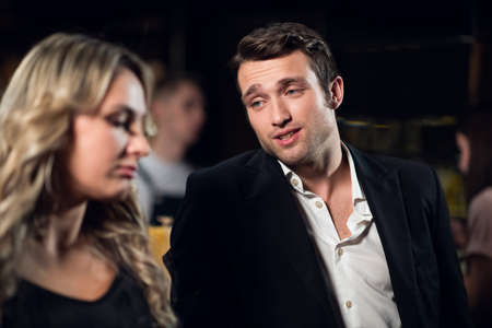 a man meets a beautiful blonde at the bar.の写真素材