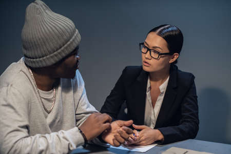 In the interrogation room, a suspect in a drug distribution and possession case consults with a public defender.の写真素材