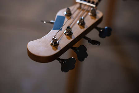 tuning pegs and fretboard bass guitar close up on the background of the musicians apartment with copy spaceの写真素材