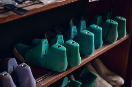 Colorful blanks for shoes are on the shelves in the cabinet in the shoe production studio.