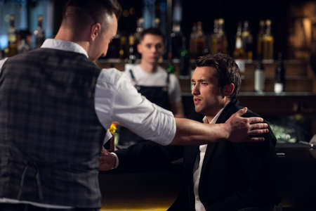 two male friends meet at the bar at the counter and communicate.の写真素材