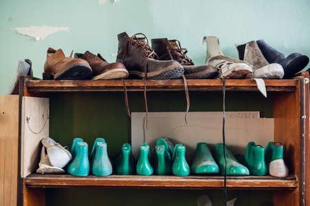 In the workshop in a wooden rack are colored blanks for different shoes.の写真素材