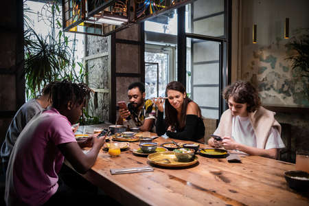 A multi-ethnic group of students eating in a modern cafe with free wifi internet.の写真素材